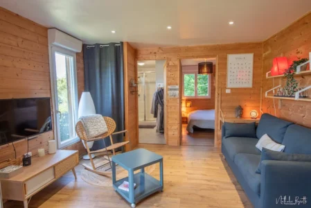 Vue d’ensemble intérieure du chalet avec salon, salle d’eau et chambre.