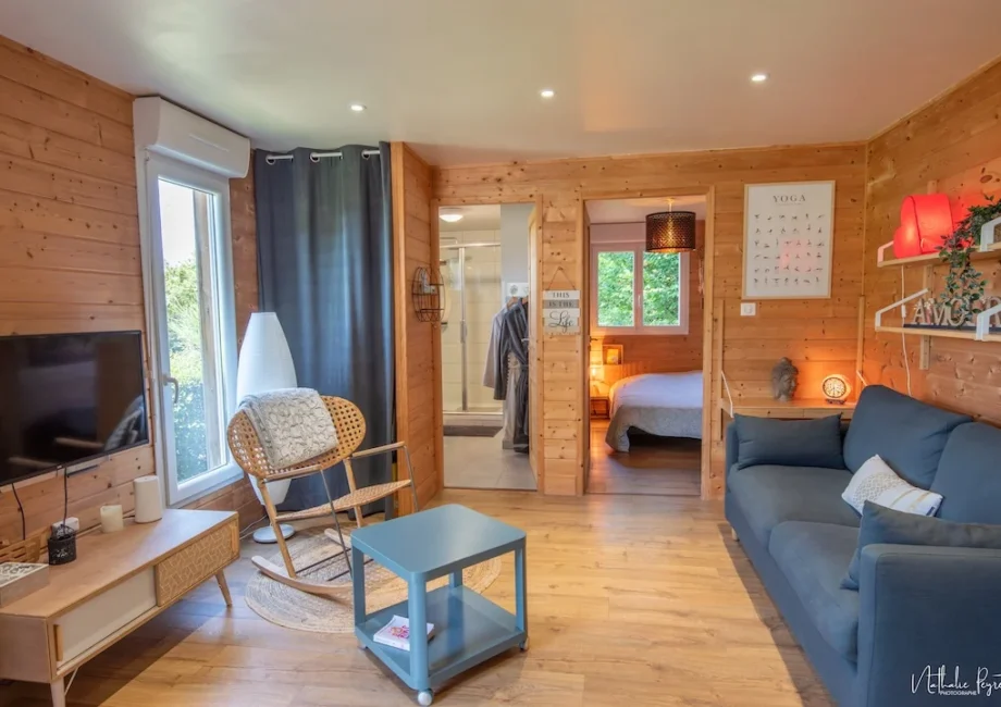 Vue d’ensemble intérieure du chalet avec salon, salle d’eau et chambre.